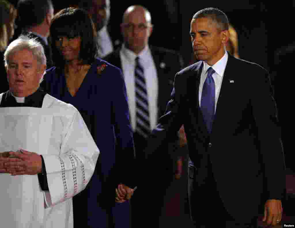 Presiden AS Barack Obama dan ibu negara Michelle Obama tiba di tempat upacara antar agama untuk para korban pemboman pada Marathon Boston di Katedral Salib Suci di Boston, Massachusetts (18/4).