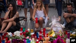 A girl places a candle after a terror attack that killed 14 people and wounded over 120 in Barcelona, Spain, Aug. 20, 2017. (