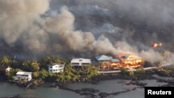 Lava destroys homes in the Kapoho area, east of Pahoa, during ongoing eruptions of the Kilauea volcano in Hawaii, June 5, 2018.