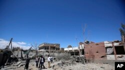 FILE - Yemeni people inspect the damage after an airstrike by Saudi-led coalition in Sana'a, Yemen, Saturday, Feb. 27, 2016. 