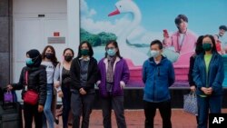 People wait to cross a street in Hong Kong, Jan. 9, 2022.