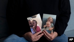 اسرائیل کے شہر ہرزیلیہ میں، یفات زیلر اپنے کزن، شیری بیباس، سینٹر، اپنے شوہر یارڈن، بائیں، اور ان کے بیٹوں ایریل، اوپر دائیں، اور کفیر کی تصاویر دکھا رہی ہیں، جنہیں غزہ کی پٹی میں حماس کے عسکریت پسندوں کے ہاتھوں یرغمال بنایا گیا ہے: بدھ، جنوری 15، 2025۔ (اے پی فوٹو)