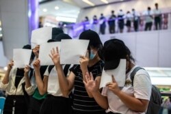 FILE - Protesters hold up blank papers during a demonstration in a mall in Hong Kong on July 6, 2020, in response to a national security law which makes political views, slogans and signs advocating Hong Kong’s independence or liberation illegal.