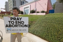 An abortion opponent sings to herself outside the Jackson Womens Health Organization clinic in Jackson, Mississippi, Oct. 2, 2019.
