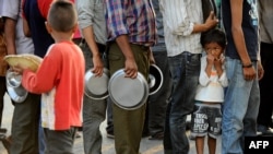 FILE - People line up to receive food and goods at a relief camp for survivors of the Nepal earthquake in Kathmandu, May 19, 2015.