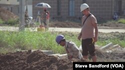 A Chinese engineer watches over a Burmese laborer at the construction site of the Chinese resort project, near Shwe Koko, Karen state, Myanmar.