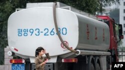 북한 평양 시내 주유소 근무자가 유조차 인근을 지나고 있다. (자료사진)