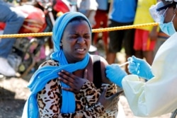 FILE - A woman reacts as a health worker injects her with the Ebola vaccine, in Goma, Democratic Republic of Congo, Aug. 5, 2019.
