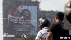 FILE - Motorists ride past a billboard displaying Facebook's Free Basics initiative in Mumbai, India.