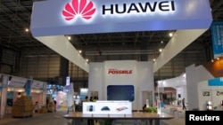 FILE - Workers prepare a stand for Huawei at the venue of the 21st Century Maritime Silk Road International Expo in Dongguan, in Guangdong Province, China, Oct. 28, 2015. 