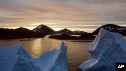 An aerial view of large Icebergs floating as the sun rises near Kulusuk, Greenland, early Aug. 16, 2019. 