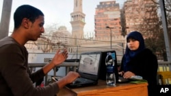 FILE - Egyptians log on to the Internet at a community center in front of a mosque in Cairo, Egypt, Saturday, Feb. 9, 2013. 