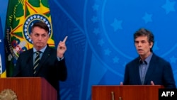 A photo by Agencia Brasil shows Brazil's President Jair Bolsonaro, left, and his new Health Minister Nelson Teich during a news conference at the Planalto Palace in Brasilia, Brazil, April 16, 2020. 