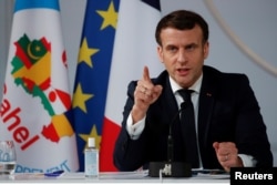 FILE - French President Emmanuel Macron gestures as he delivers a speech after a meeting via video-conference with leaders of West African G-5 Sahel nations, in Paris, France, Feb. 16, 2021.