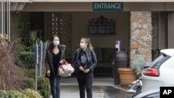 지난 2일 미국 워싱턴주 커클랜드에서 마스크를 착용한 두 여성이 라이프케어센터를 벗어나고 있다. 