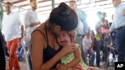 A Venezuelan woman holds a girl at a health post for migrants in Cucuta, along Colombia's border with Venezuela, July 16, 2018. 