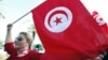 A woman waves a Tunisia flag during a rally to protest against religious and political violence in Tunis, Oct. 22, 2012. 