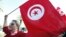 A woman waves a Tunisia flag during a rally to protest against religious and political violence in Tunis, Oct. 22, 2012. 