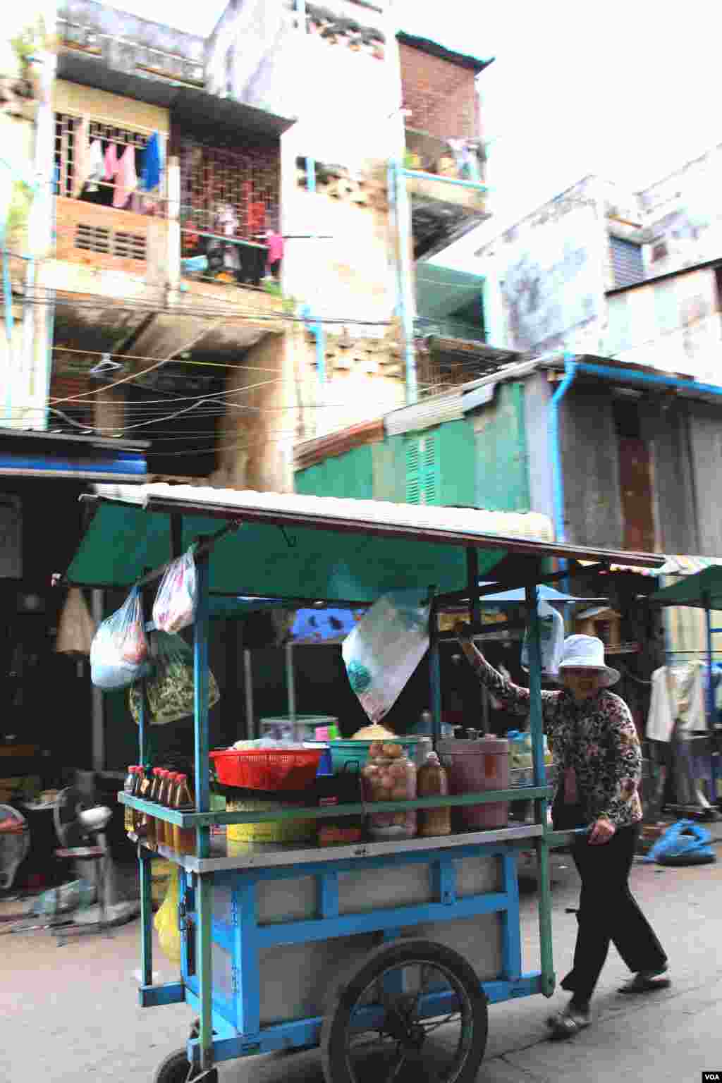 អ្នក​លក់​រុញ​រទេះ​នៅ​តាម​ផ្លូវ​នៅ​មុខ​អគារ​ប៊ូលឌីង​កាល​ពី​ថ្ងៃ​សុក្រ​ទី​៥ ខែ​កញ្ញា ឆ្នាំ​២០១៤។ (នូវ ពៅលក្ខិណា/VOA) 