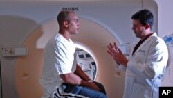 Former NFL player Marc Cerqua, left, and interventional radiologist Constantino S. Pena discuss the findings a CT scan looking for calcium buildup in the heart, Tuesday, Jan. 30, 2007, at the Baptist Cardiac & Vascular Institute in Miami. (AP Photo/David 