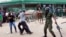 A police officer fires pepper spray at supporters of the opposition United Party for National Development outside the Woodlands Police Station in Lusaka, March 2, 2016. 