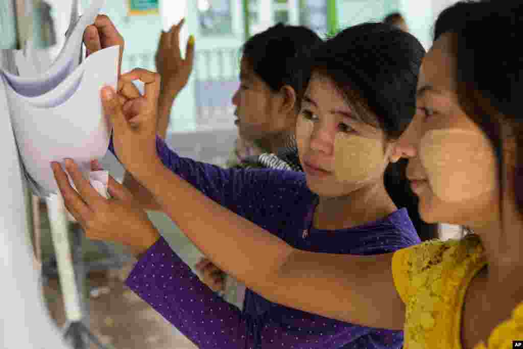 Women search for names on a voter&#39;s registration list at a polling station in the village of Dala, Nov. 8, 2015.
