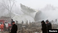 Des membres de l'équipe de secours et d'enquêteurs travaillent sur le lieu de l'accident dans la ville de Bishkek, au Kirghizstan, le 16 janvier 2017.