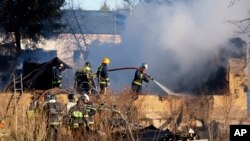 Ministry for Emergency Situations workers and fire fighters work at a site of a fire of a psychiatric hospital, April 26, 2013.