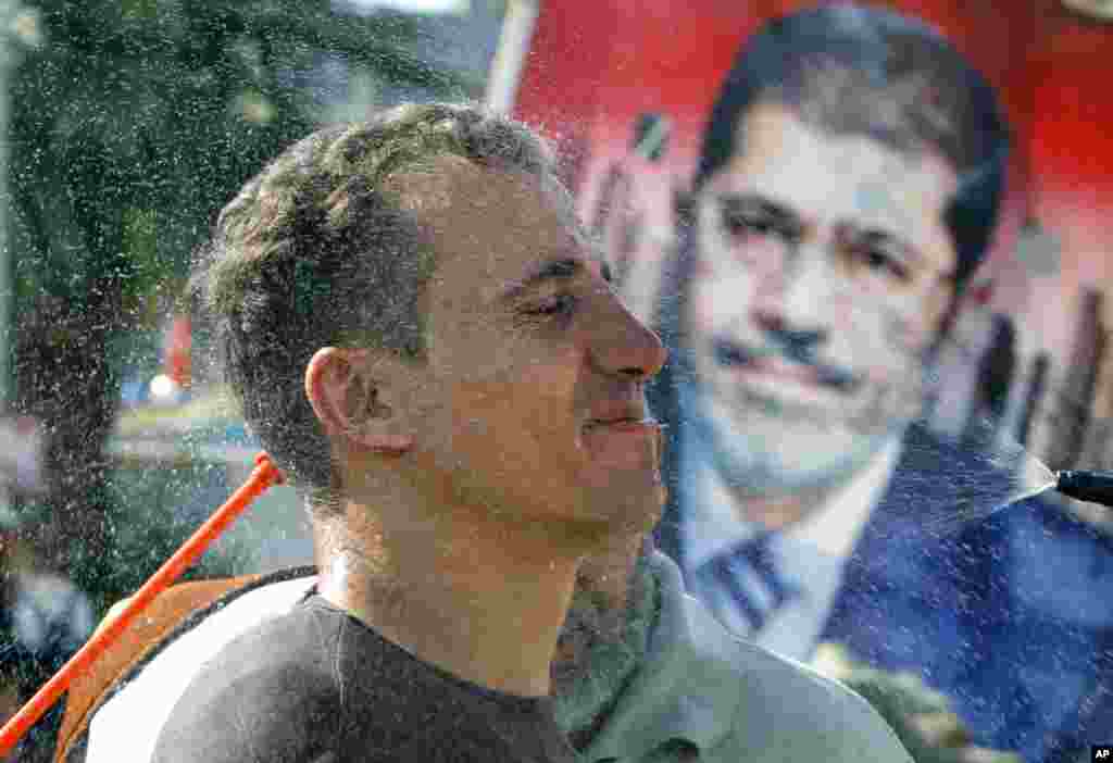 An Egyptian woman feeds her ducks in front of a barrier recently set up by supporters of Egypt&#39;s ousted President Mohamed Morsi in their camp in Giza, southwest of Cairo, Egypt, Aug. 1, 2013.&nbsp;