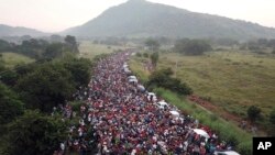 Kelompok migran Amerika Tengah berdiri di jalanan setelah polisi federal dengan tegas memblokir jalan mereka di luar kota Arriaga, Sabtu, 27 Oktober 2018.