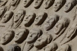 A sand sculpture features faces representing COVID-19 victims on Copacabana beach in Rio de Janeiro, Brazil, June 17, 2020.