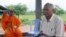 FILE - Meas Muth, right, sits next to a Buddhist monk at Anlong Veng district in Oddar Mean Chey province, Cambodia, July 23, 2006. Meas Muth was implicated in the 1975 Mayaguez incident in which at least 38 U.S. servicemen died.
