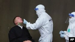 រូបឯកសារ៖ បុរសម្នាក់ត្រូវបានយកសំណាកដើម្បីធ្វើតេស្តរកវីរុសកូរ់ូណា នៅព្រលានយន្តហោះយោធា ក្នុងក្រុងបាងកក ប្រទេសថៃ កាលពីថ្ងៃទី០៩ ខែកក្កដា ឆ្នាំ២០២០។