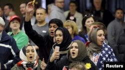 FILE - Young Muslims protest US Republican presidential candidate Donald Trump before being escorted out during a campaign rally in the Kansas Republican Caucus at the Century II Convention and Entertainment Center in Wichita, Kansas, March 5, 2016.