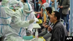 រូបឯកសារ៖ បុគ្គលិក​ពេទ្យ​ម្នាក់​ធ្វើតេស្ត​ទៅលើ​អ្នករស់នៅ​ក្រុង​វូហាន​ដើម្បី​រកមើល​ជំងឺ​កូវីដ១៩ នៅក្រុង​វូហាន ខេត្តហ៊ូប៉ី ភាគកណ្តាល​ប្រទេស​ចិន។