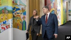 Ukrainian President Petro Poroshenko, right, and European Union foreign policy chief Federica Mogherini talk during a meeting at the presidential office in Kyiv, Ukraine, March 12, 2018. 