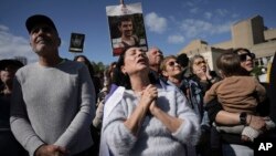  8 فروری 2025 کو ہفتے کے روز، حماس کی جانب سے رہا کیے جانے والے یرغمالوں کے عزیز یرغمالوں کے پوسٹرز تھامے تل ابیب، اسرائیل میں ایک ٹیلی ویژن اسکرین پر ان کی رہائی کو براہ راست دیکھتے ہوئے ، اپنے رد عمل کا اظہار کر رہے ہیں۔ (فوٹو اے پی)