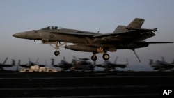 Jet tempur Koalisi AS untuk serangan terhadap ISIS mendarat di atas kapal di Teluk Persia, setelah terbang dari Irak. (AP/Hasan Jamali)