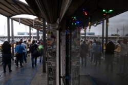 People queue to cross to the United States at San Ysidro crossing port on the Mexican side of the US - Mexico border in Tijuana, Baja Caifornia state, on Aug. 20, 2021.
