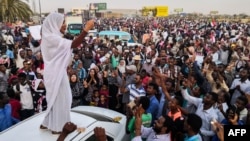 FILE - Alaa Salah, a Sudanese woman propelled to internet fame after clips went viral of her leading protest chants against President Omar al-Bashir, addresses protesters during a demonstration in front of the military headquarters in the capital Khartoum, April 10, 2019.