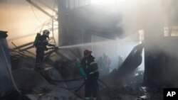 Para petugas damkar mematikan api kebakaran usai serangan drone Rusia di Kharkiv, Ukraina, 25 Mei 2024. (Foto: Andrii Marienko/AP Photo)