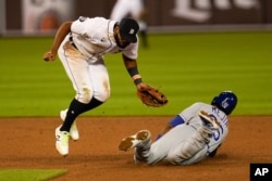 FILE - Kansas City Royals' Erick Mejia steals second base under the tag of Detroit Tigers shortstop Willi Castro (49)in the ninth inning of a baseball game in Detroit, Wednesday, Sept. 16, 2020. (AP Photo/Paul Sancya)