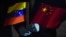 FILE - Venezuelan Foreign Minister Jorge Arreaza, wearing protective gloves as a preventive measure against the spread of COVID-19, holds Venezuelan and Chinese flags at the Simon Bolivar International Airport in La Guaira, Venezuela, on March 30, 2020.