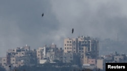 Burung beterbangan, saat asap membubung di atas Gaza, di tengah konflik yang terus berlangsung antara Israel dan kelompok Hamas, terlihat dari Israel selatan, 8 Desember 2023. (REUTERS/Amir Cohen)