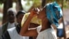 Woman drinking the first dose of the first oral vaccine against cholera in Africa during an epidemic, Guinea, Tougnifili/Mankountan, 2012. Photo by David Di Lorenzo/MSF. 