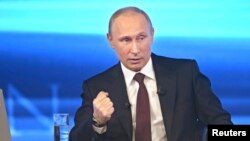 Russian President Vladimir Putin takes part in a live broadcast nationwide phone-in, in Moscow, Apr. 17, 2014. 