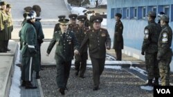 Para delegasi Korea Utara (tengah) saat memasuki perbatasan Korsel di Panmunjom sementara delegasi Korsel menunggu sebelum berlangsung pembicaraan Rabu (9/2).