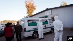 지난달 27일 평양 순안 공항에서 안전복장을 착용한 의료진이 구급차 옆에서 대기하고 있다. (자료사진)