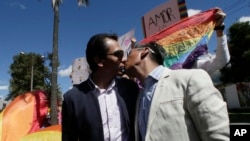 Javier Benalcázar, izquierda, y su pareja Efraín Soria se besan a su llegada a la Corte Constitucional para escuchar la decisión final del organismo sobre el matrimonio igualitario en Quito, Ecuador, el martes 4 de junio de 2019. (AP Foto/Dolores Ochoa).