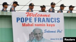 Polisi melewati spanduk bergambar Paus Fransiskus di Manila, Filipina (15/1). 